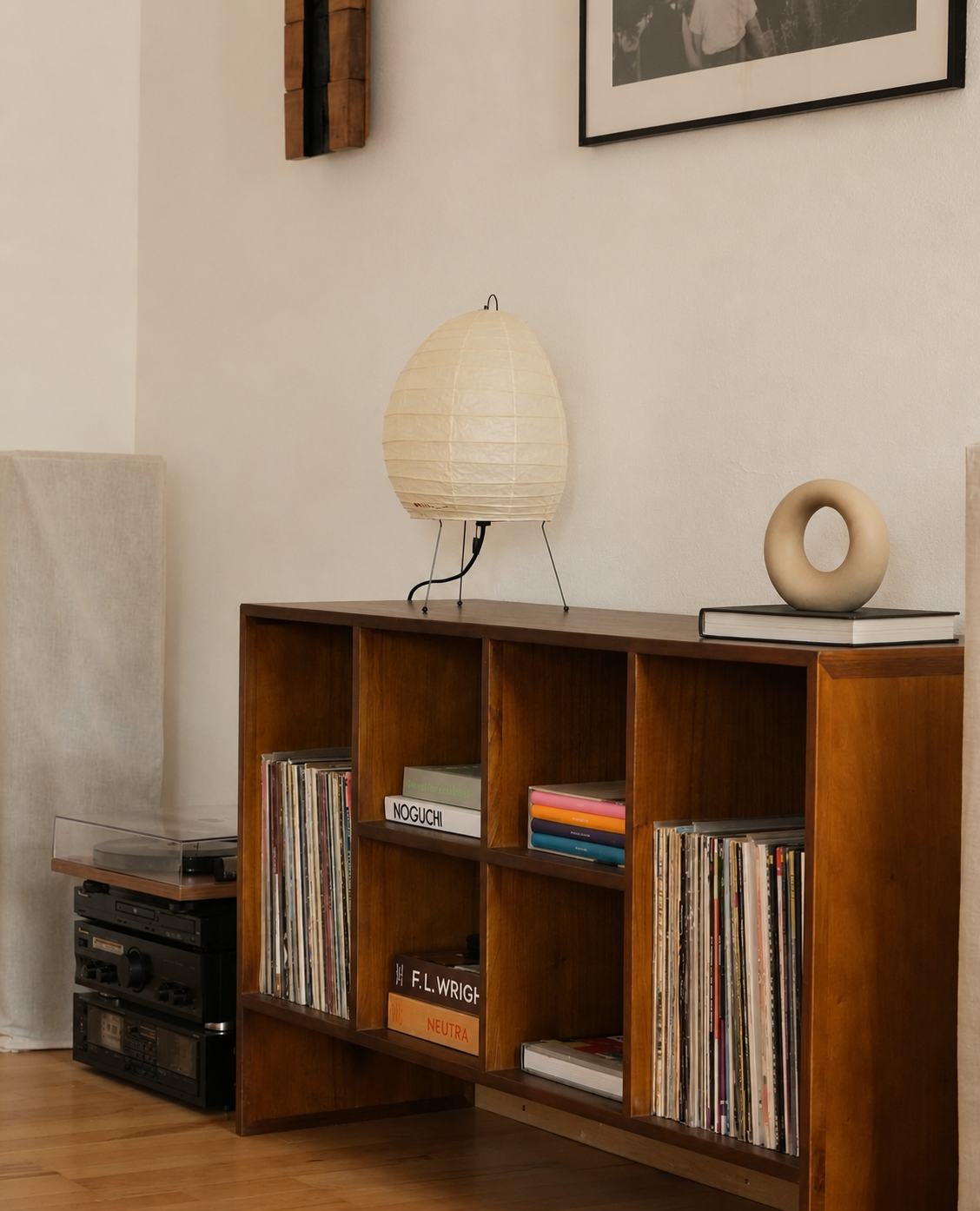 Paper lamp and sculpted ring on a vintage record shelf